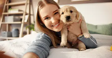 Junge Frau mit ihrem Welpen im Arm