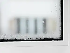 Wasser kondensiert am undichten Fenster