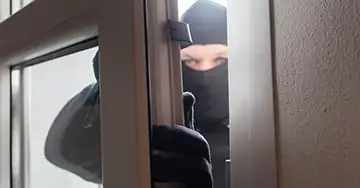 Einbrecher am gekippten Fenster