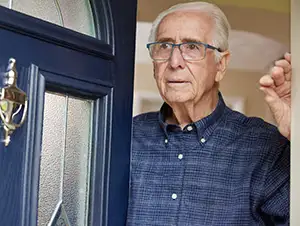 älterer Mann öfnet die Tür